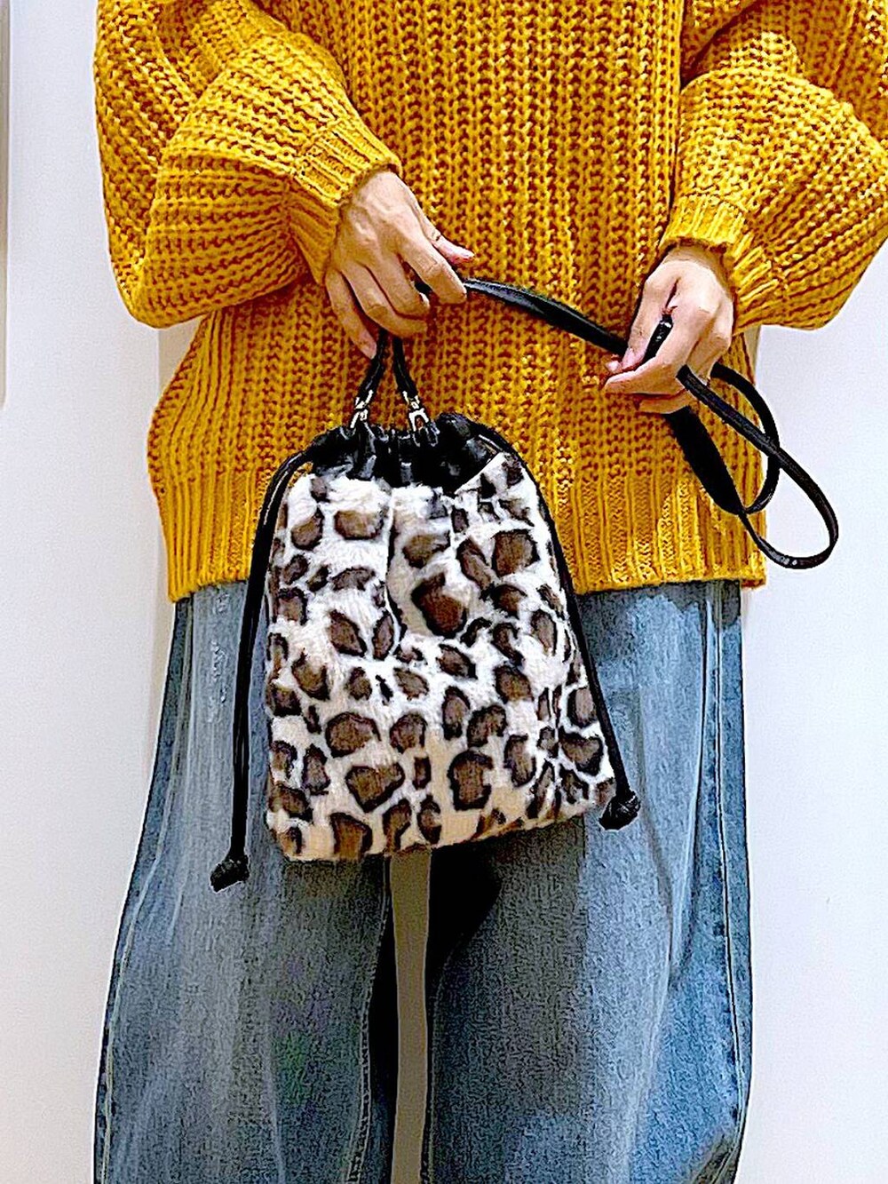 ベージュ系のブーツ、その他のショルダーバッグ、ブルー系のデニムパンツを着用したレディースの冬コーディネートの9枚目の写真