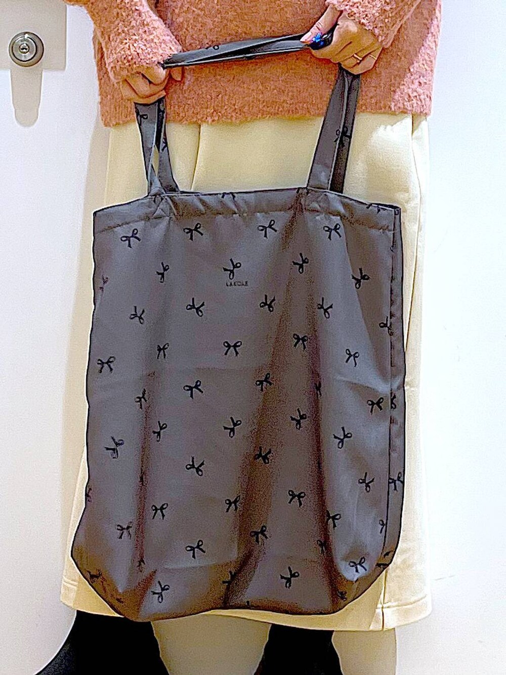 ブラック系のブーツ、その他のトートバッグ、ピンク系のニット/セーターを着用したレディースの冬コーディネートの9枚目の写真