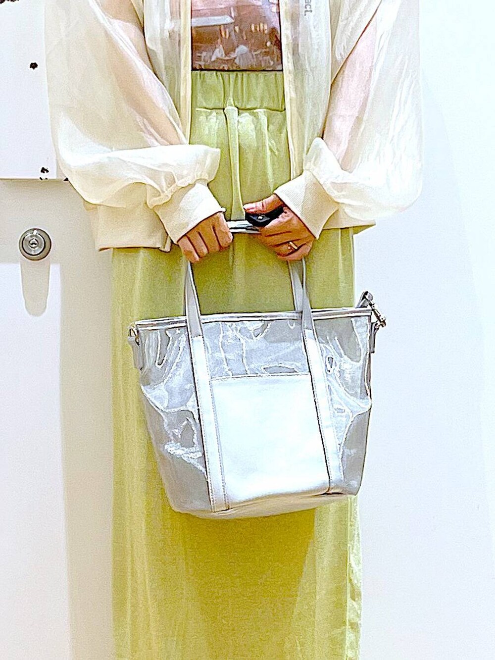 グリーン系のスカート、シルバー系のサンダル、シルバー系のトートバッグを着用したレディースの夏コーディネートの9枚目の写真