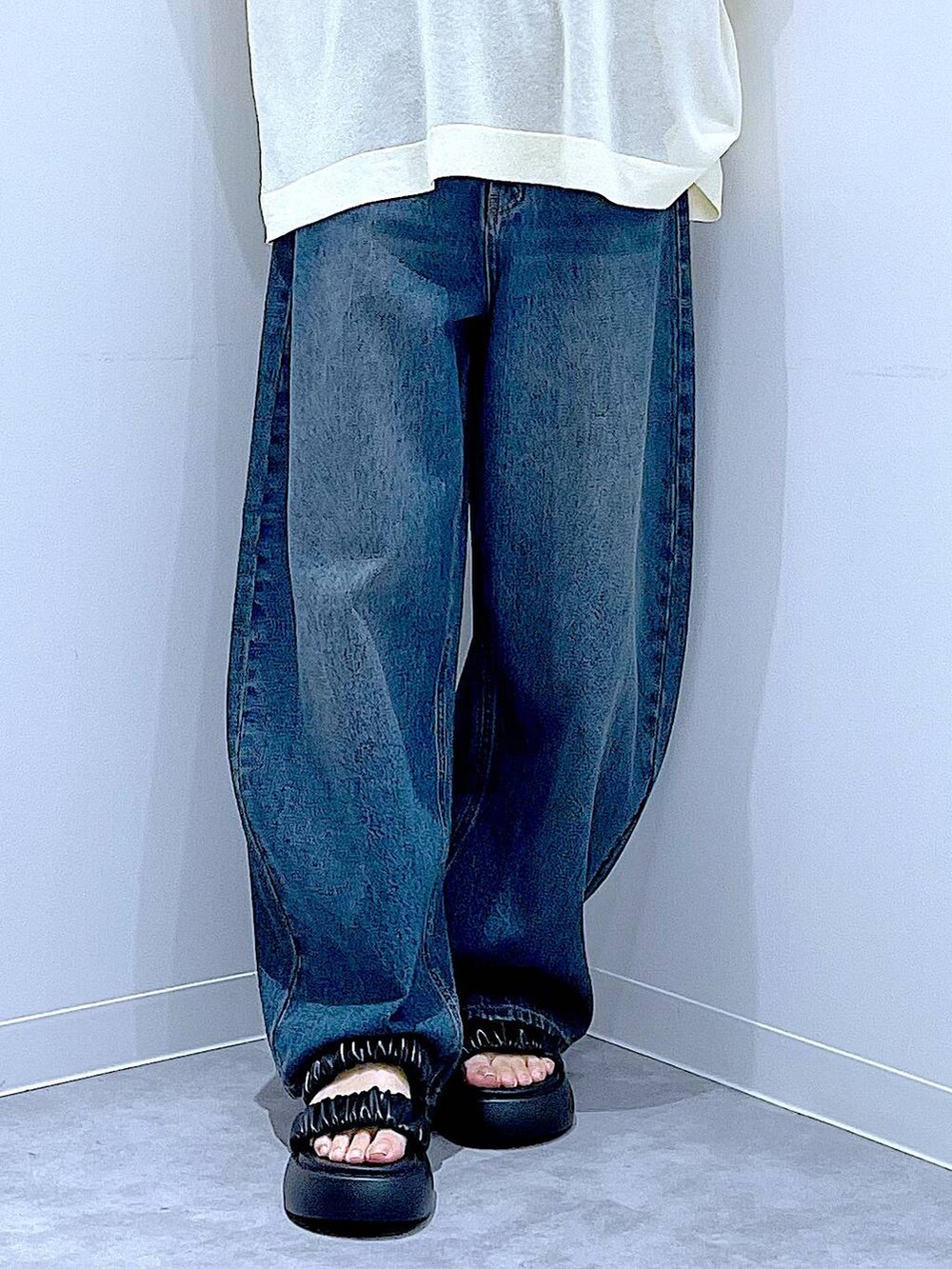 ブルー系のデニムパンツ、ブラック系のバックパック/リュック、ブラック系のサンダルを着用したレディースの夏コーディネートの8枚目の写真