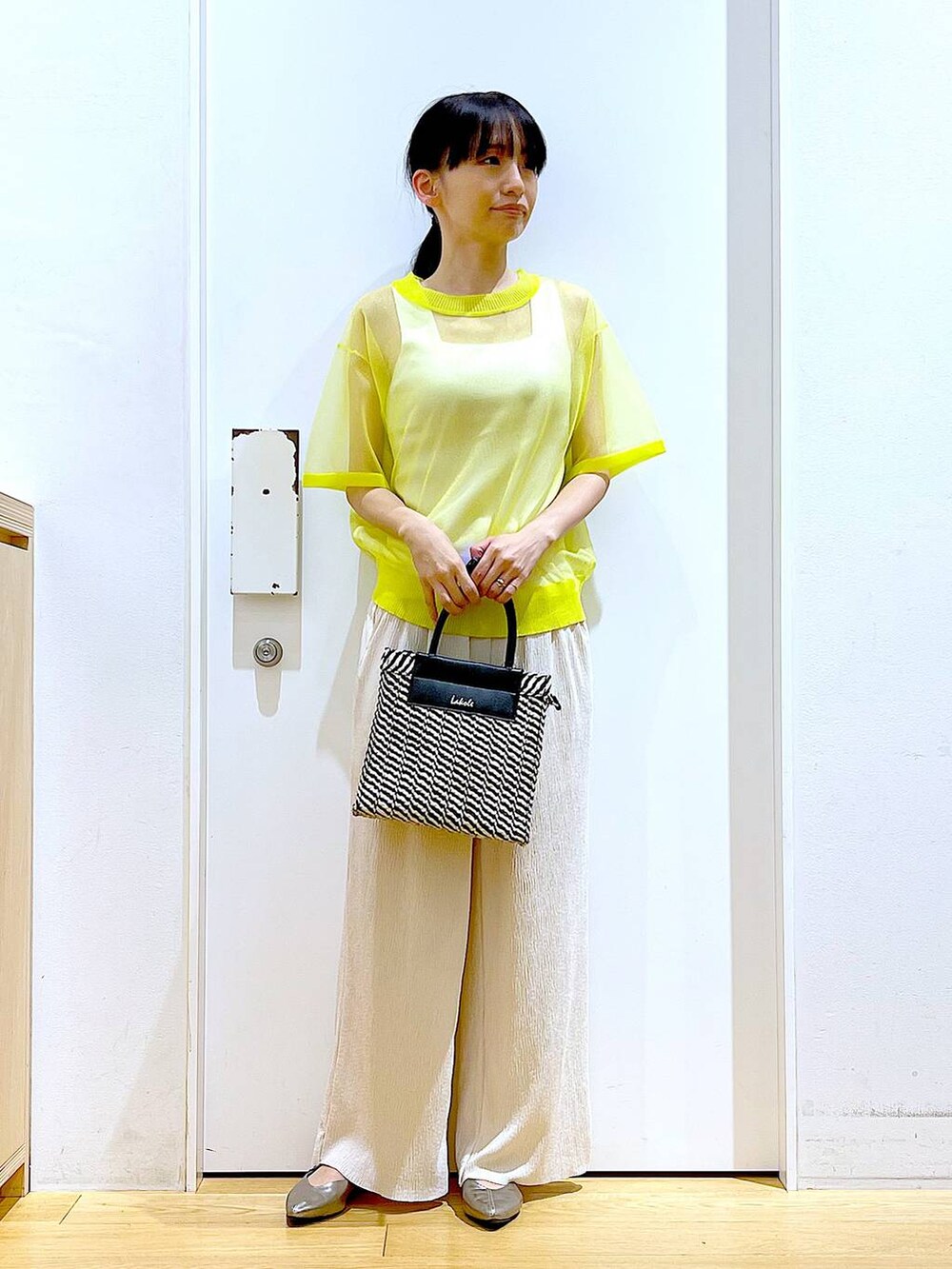 イエロー系のニット/セーター、ホワイト系のその他パンツ、ホワイト系のニット/セーターを着用したレディースの夏コーディネートの2枚目の写真