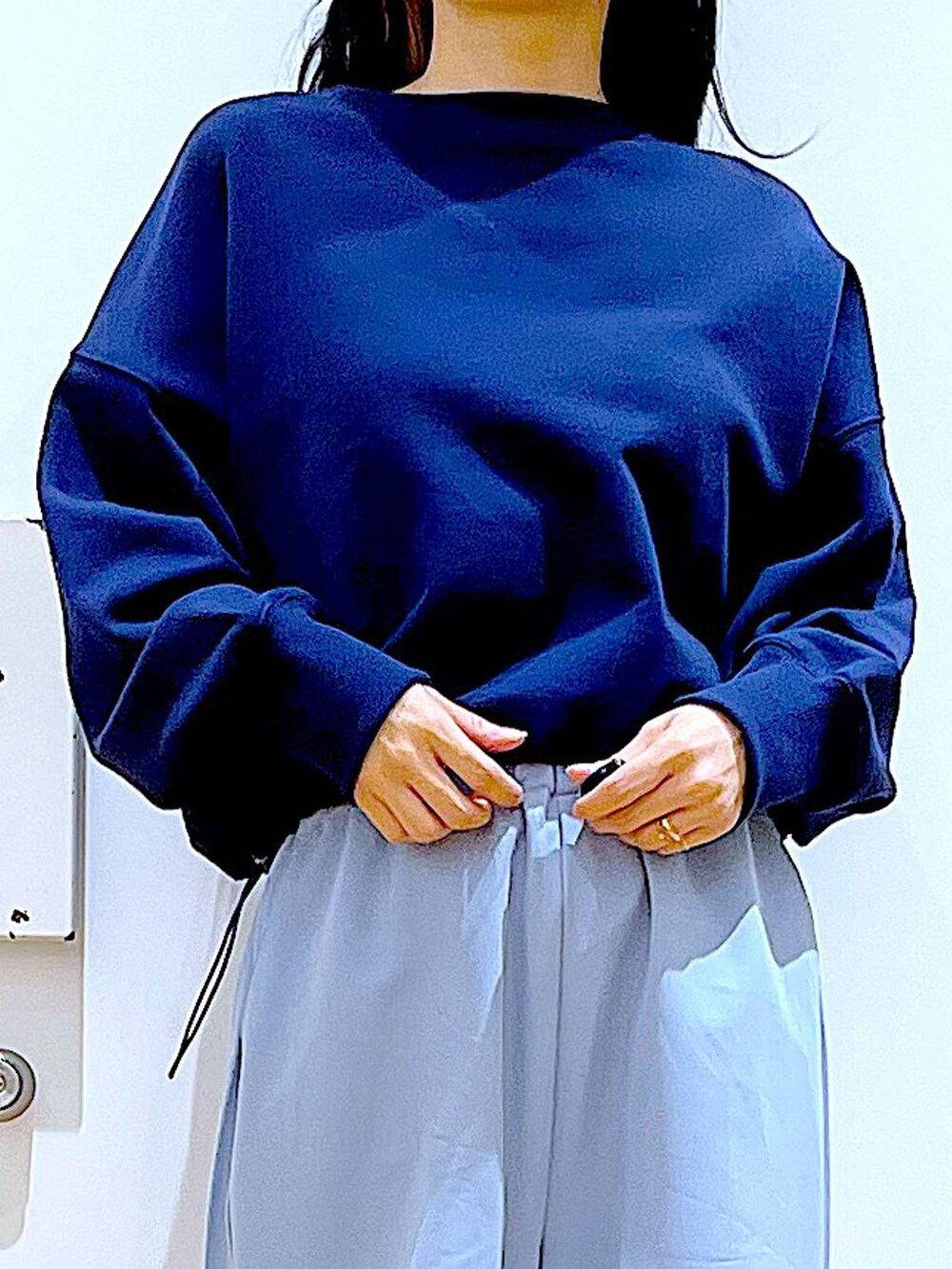 ブルー系のスウェット、ブラック系のバックパック/リュック、ベージュ系のブーツを着用したレディースの春コーディネートの7枚目の写真
