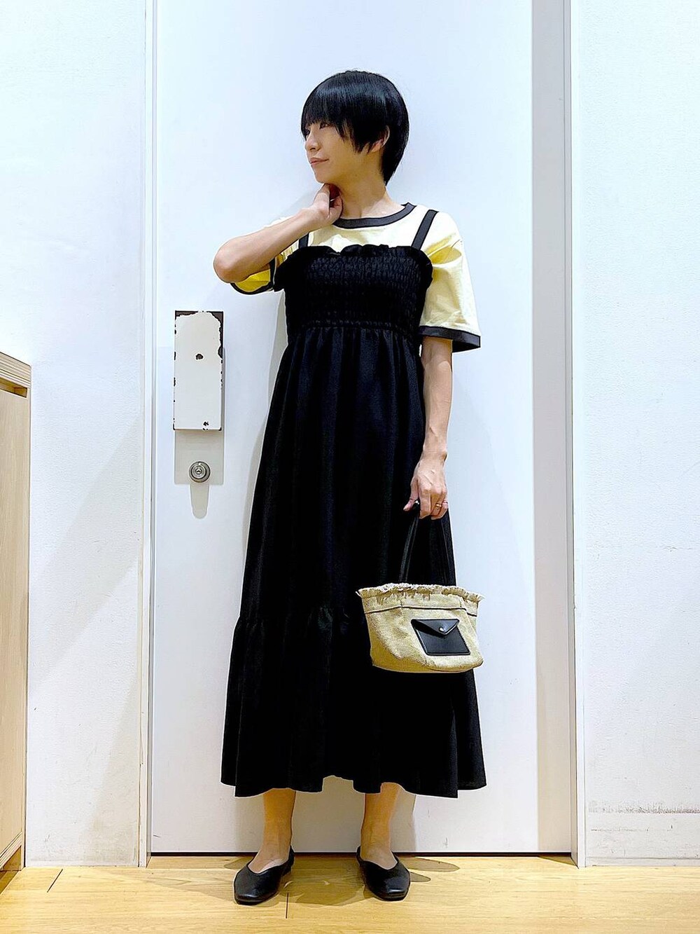 ブラック系のパンプス、ベージュ系のショルダーバッグ、ブラック系のワンピースを着用したレディースの夏コーディネートの2枚目の写真