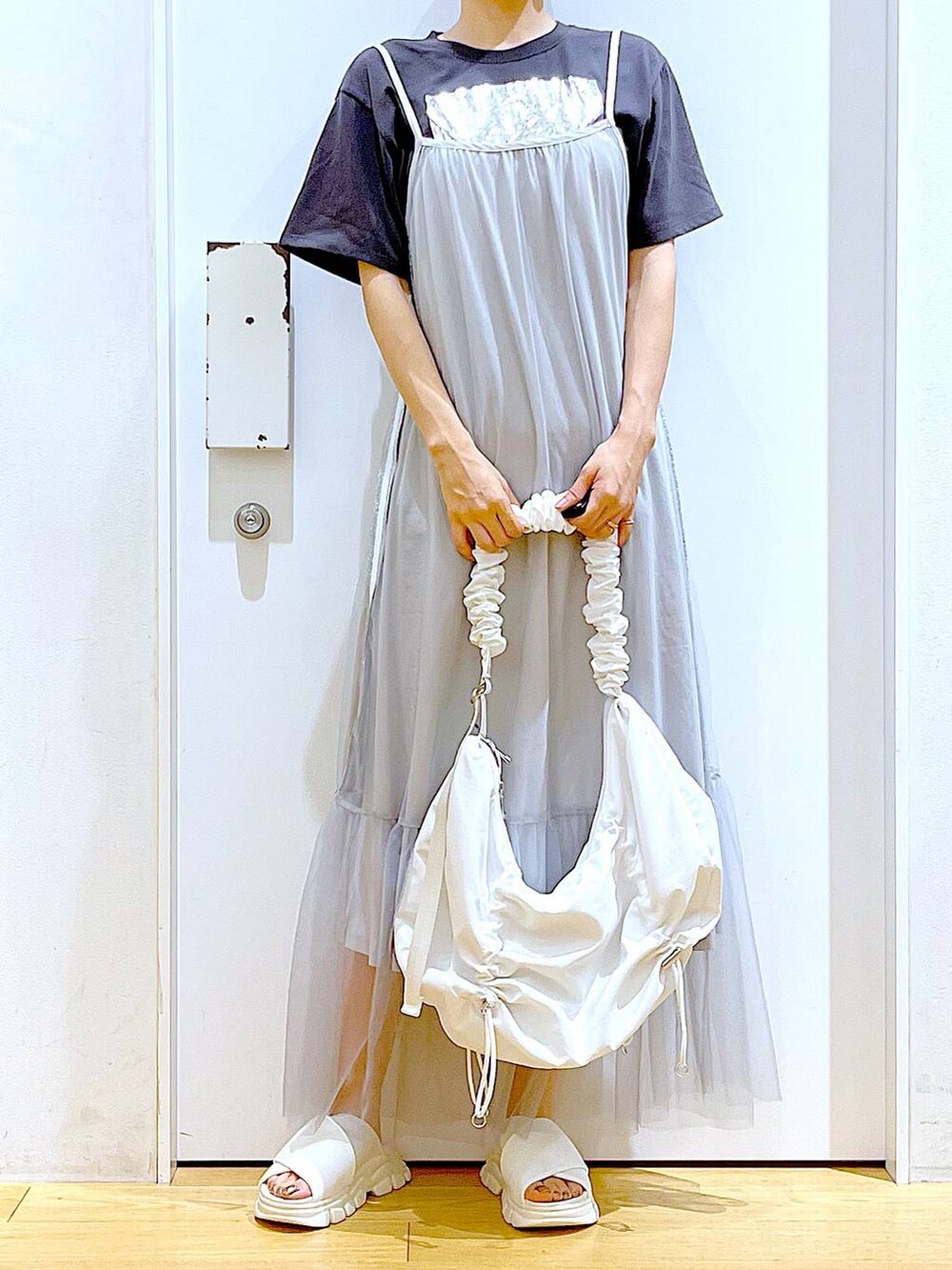 ホワイト系のサンダル、グレー系のTシャツ/カットソー、ホワイト系のショルダーバッグを着用したレディースの夏コーディネートの6枚目の写真