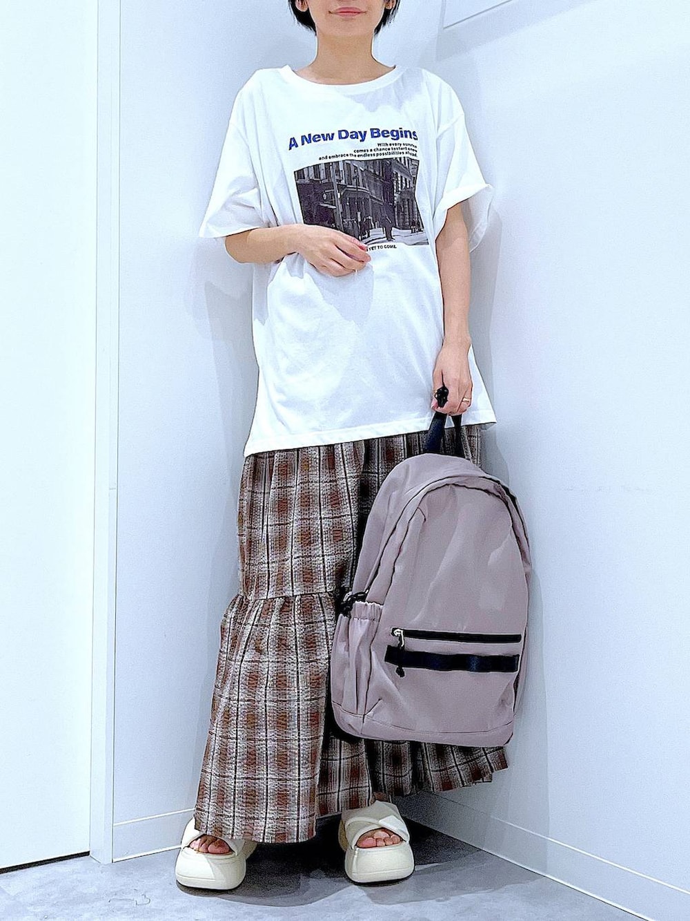 ベージュ系のバックパック/リュック、ホワイト系のサンダル、ブラウン系のワンピースを着用したレディースの夏コーディネートの6枚目の写真