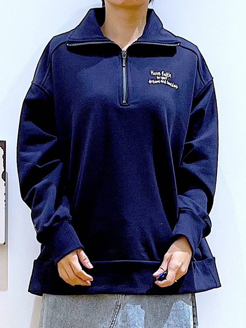 ブルー系のショルダーバッグ、ブラック系のブーツ、ブルー系のデニムスカートを着用したレディースの春コーディネートの7枚目の写真