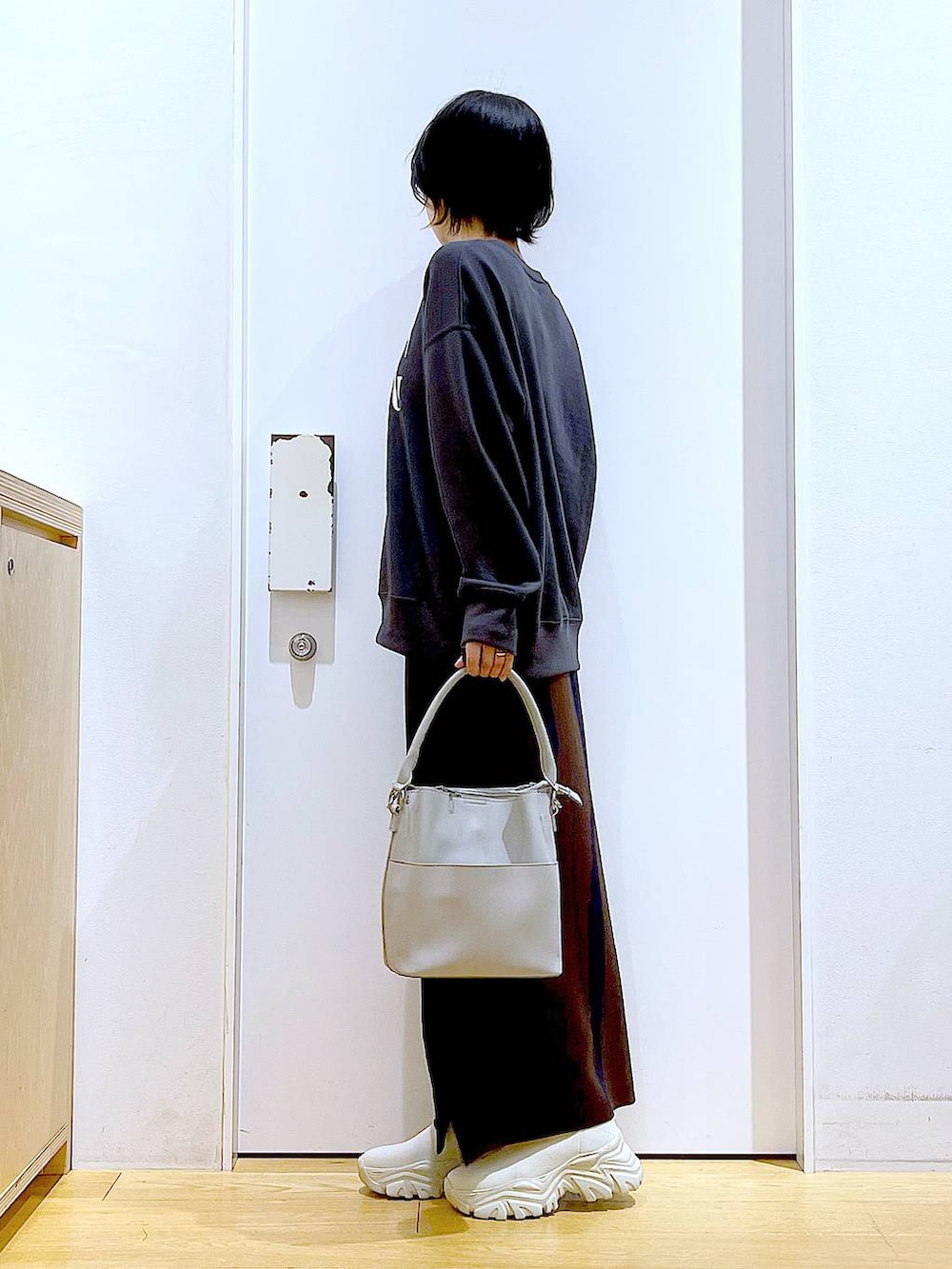 ブラウン系のスカート、グレー系のショルダーバッグ、ベージュ系のブーツを着用したレディースの冬コーディネートの3枚目の写真