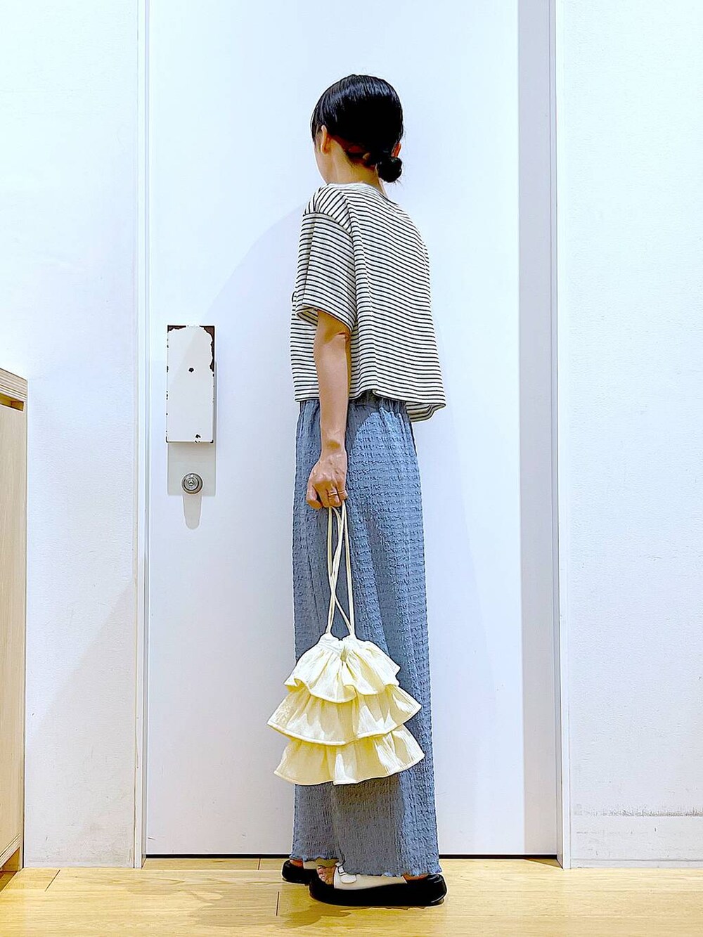 ホワイト系のサンダル、ブルー系のスカート、ホワイト系のショルダーバッグを着用したレディースの秋コーディネートの3枚目の写真