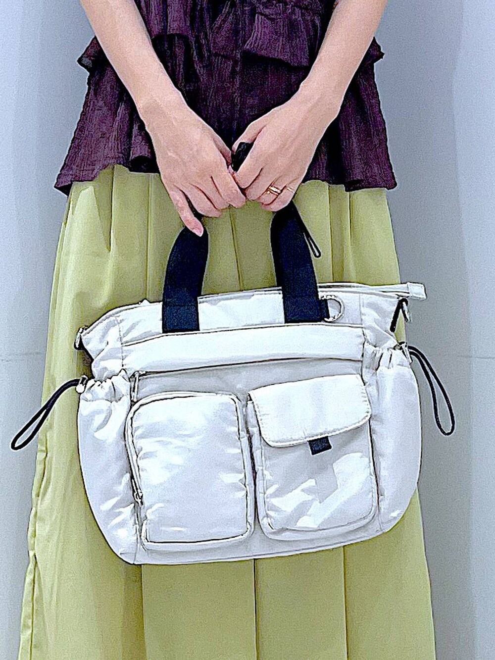 ホワイト系のトートバッグ、ブラウン系のベスト、イエロー系のその他パンツを着用したレディースの夏コーディネートの9枚目の写真