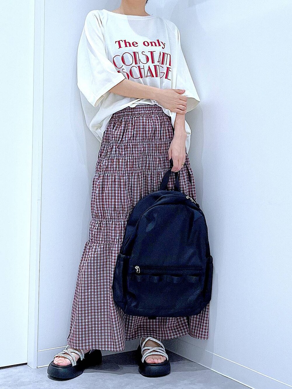 ブラック系のバックパック/リュック、シルバー系のサンダル、ホワイト系のTシャツ/カットソーを着用したレディースの夏コーディネートの6枚目の写真