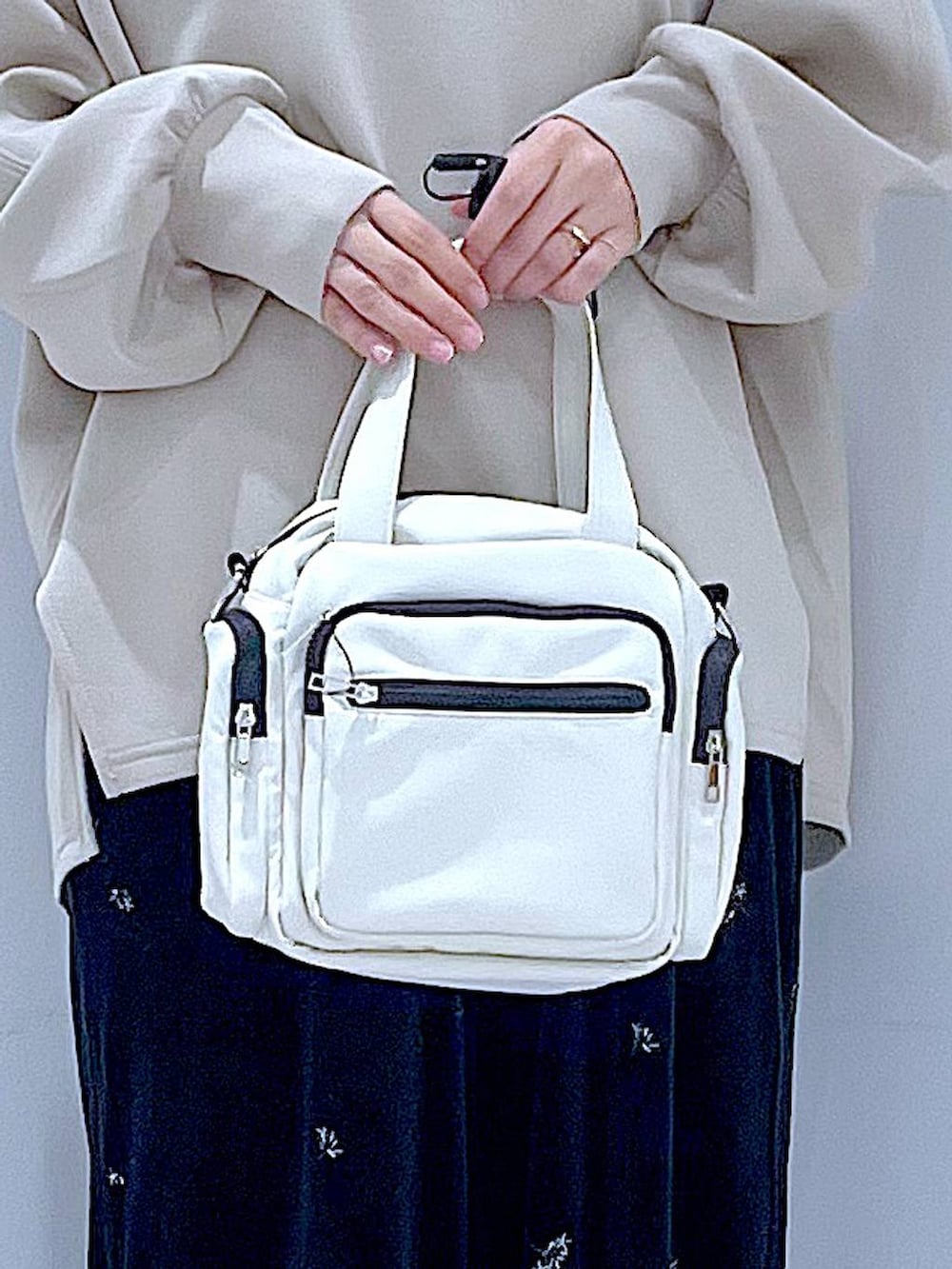 ホワイト系のショルダーバッグ、ブラック系のローファー、ブラック系のその他パンツを着用したレディースの秋コーディネートの9枚目の写真