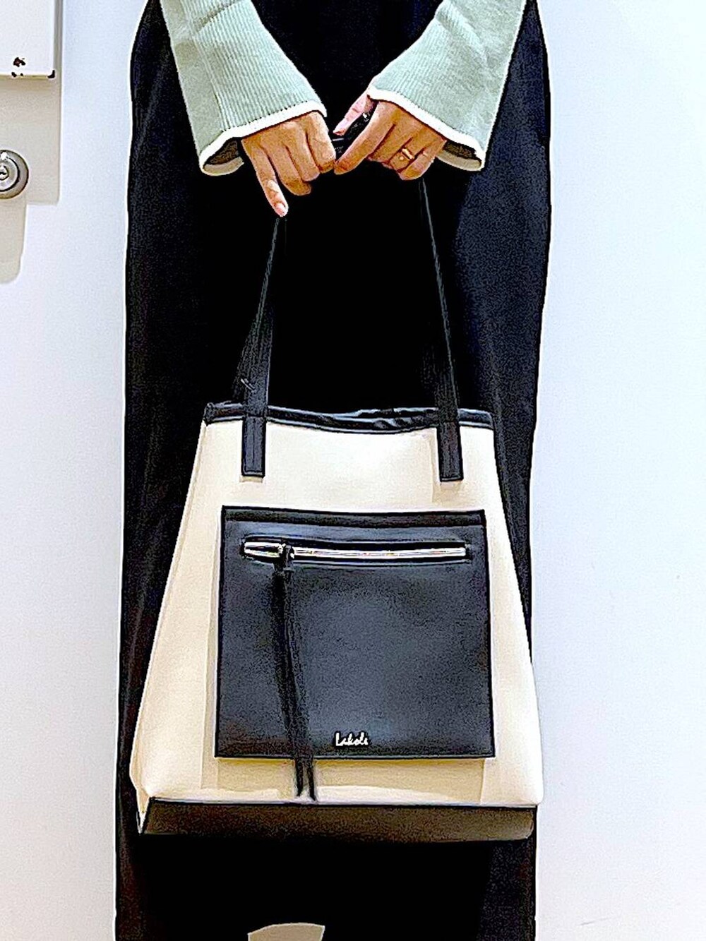 グリーン系のニット/セーター、ブラック系のブーツ、ブラック系のサロペット/オーバーオールを着用したレディースの冬コーディネートの9枚目の写真