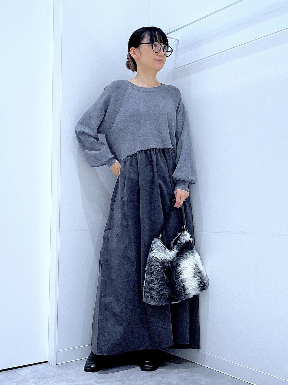 ブラック系のブーツ、ブラック系のショルダーバッグ、グレー系のワンピースを着用したレディースの秋コーディネートの2枚目の写真