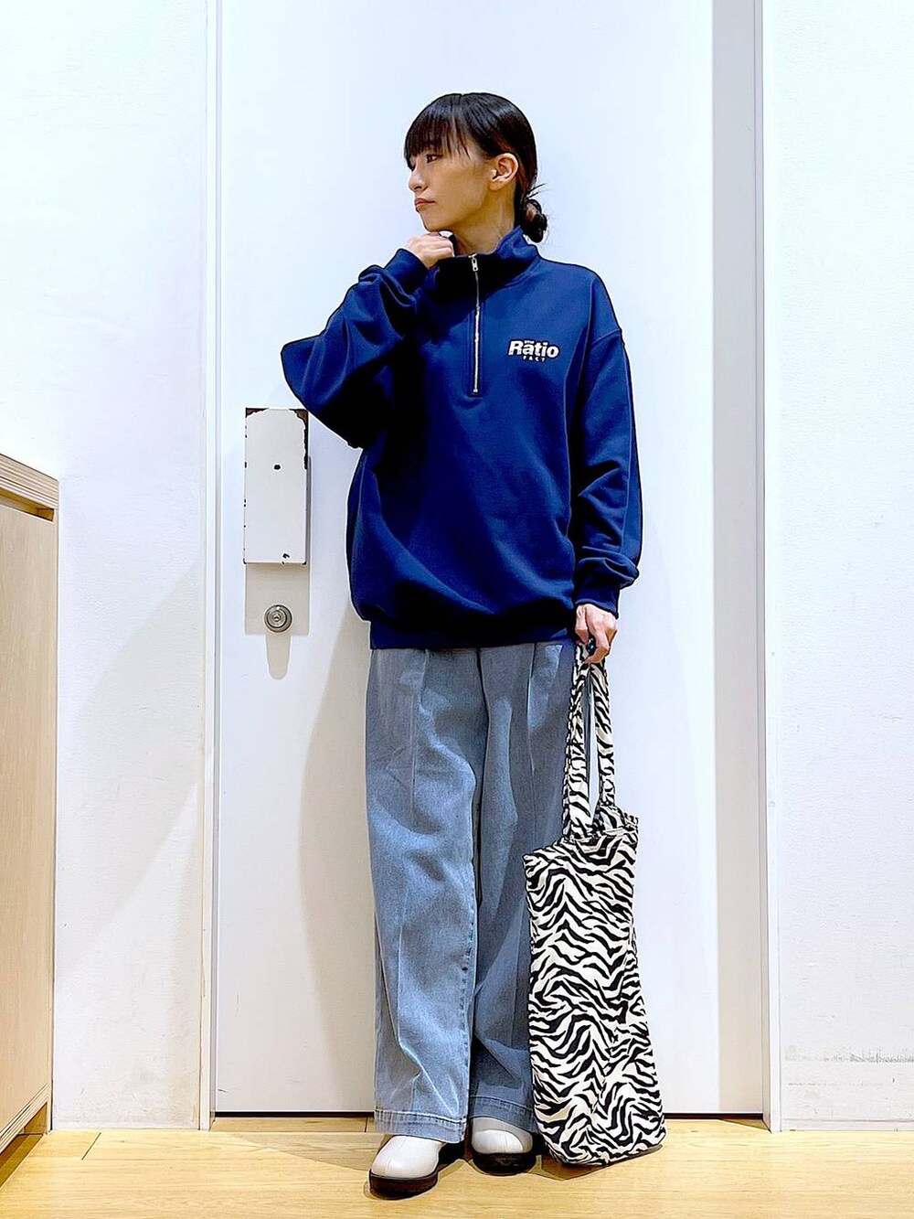 ブルー系のデニムパンツ、ブルー系のスウェット、ベージュ系のブーツを着用したレディースの春コーディネートの2枚目の写真