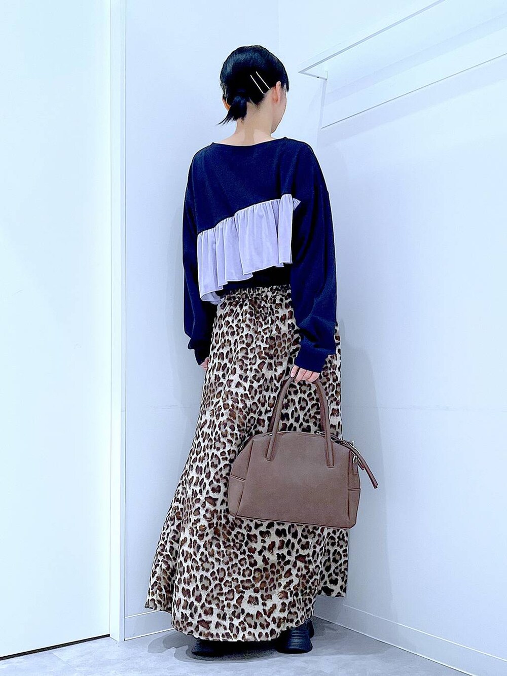 ブラック系のローファー、ブラウン系のボストンバッグ、ブラウン系のスカートを着用したレディースの秋コーディネートの5枚目の写真