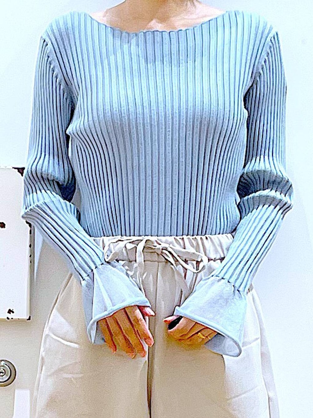 ブルー系のニット/セーター、ホワイト系のショルダーバッグ、ベージュ系のブーツを着用したレディースの冬コーディネートの7枚目の写真