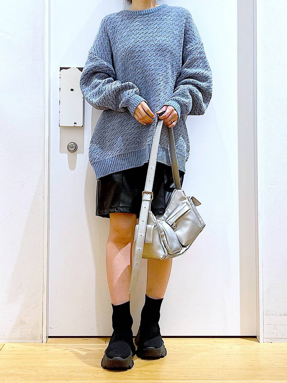 ブルー系のニット/セーター、ブラック系のブーツ、その他のショルダーバッグを着用したレディースの冬コーディネートの6枚目の写真