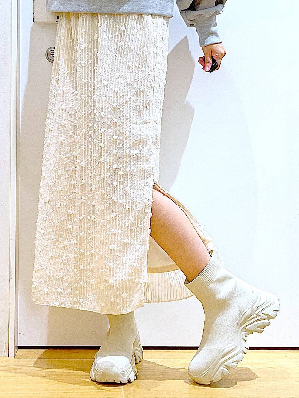 ホワイト系のハンドバッグ、グレー系のスウェット、ベージュ系のブーツを着用したレディースの秋コーディネートの8枚目の写真