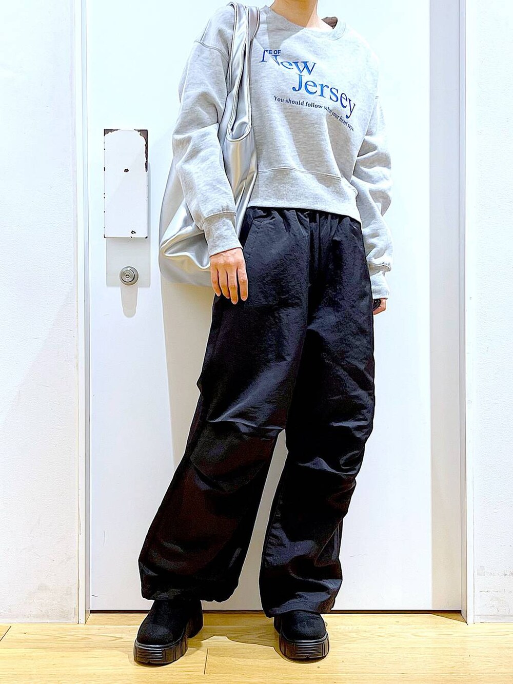 シルバー系のトートバッグ、ブラック系のブーツ、ブラック系のその他パンツを着用したレディースの冬コーディネートの6枚目の写真