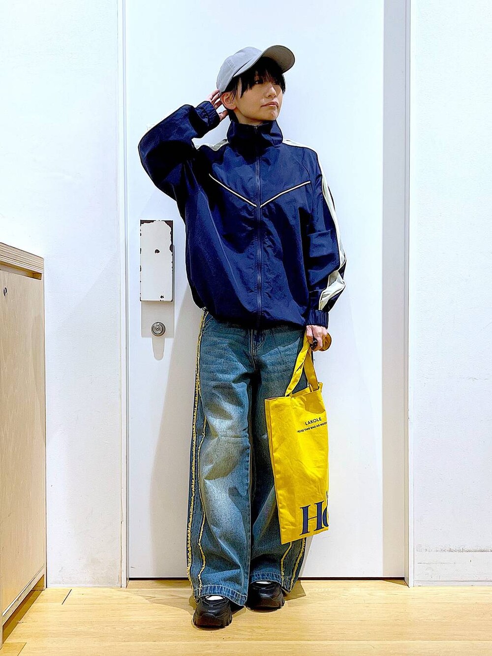 ブラック系のスニーカー、ブルー系のデニムパンツ、ブルー系のブルゾンを着用したレディースの春コーディネートの2枚目の写真