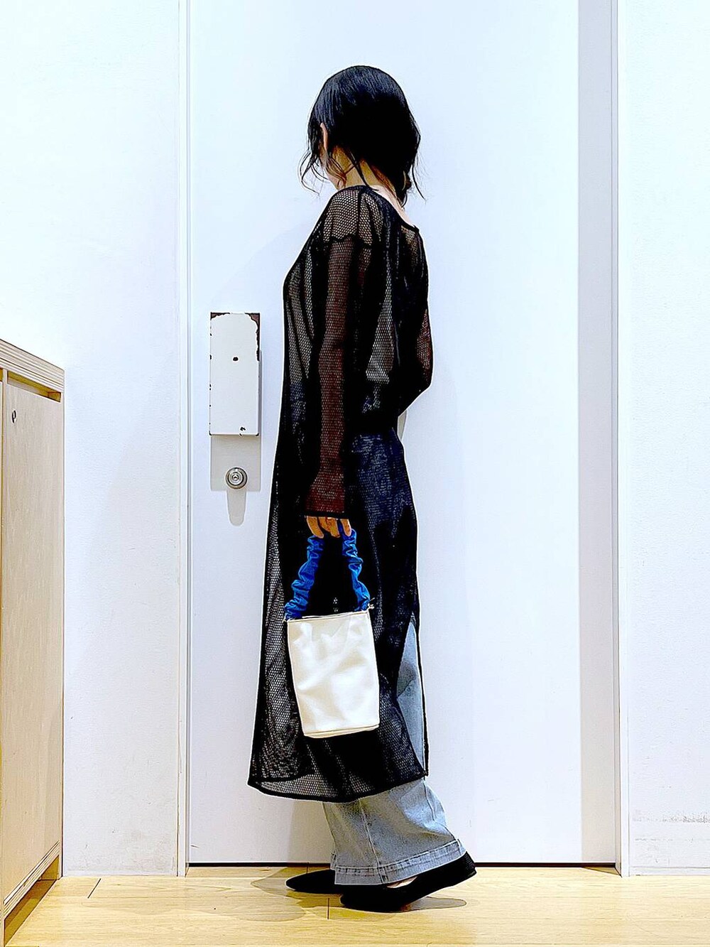 ブルー系のショルダーバッグ、ブラック系のパンプス、ブルー系のデニムパンツを着用したレディースの春コーディネートの3枚目の写真