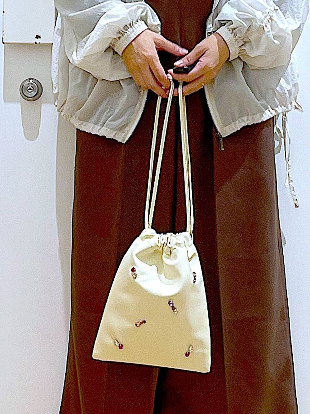 ホワイト系のショルダーバッグ、ホワイト系のパンプス、ブラック系のTシャツ/カットソーを着用したレディースの秋コーディネートの9枚目の写真