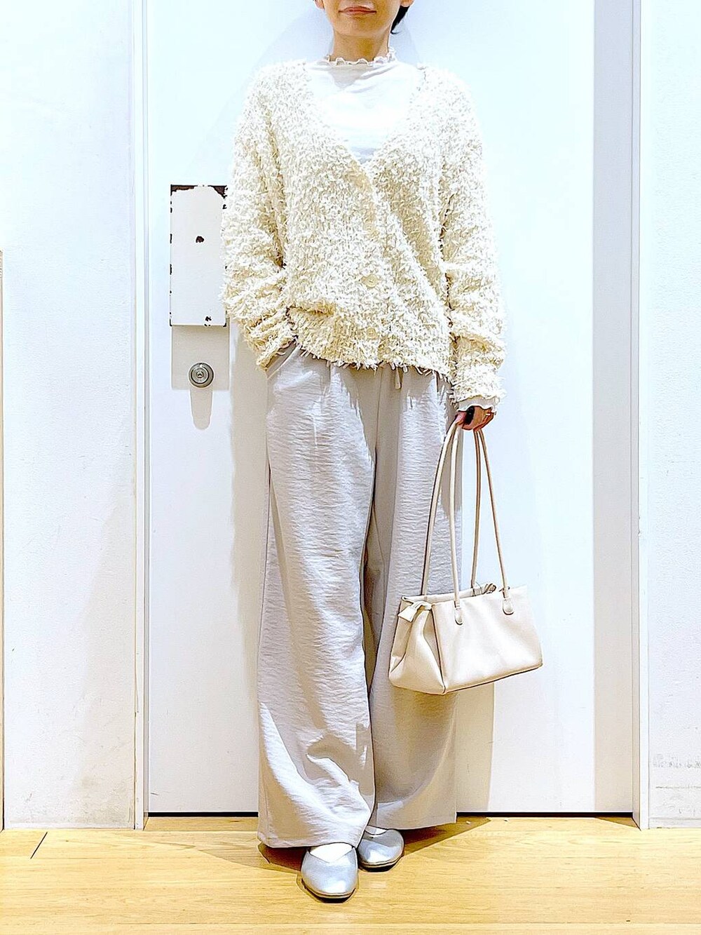 ホワイト系のトートバッグ、ベージュ系のTシャツ/カットソー、シルバー系のパンプスを着用したレディースの冬コーディネートの6枚目の写真