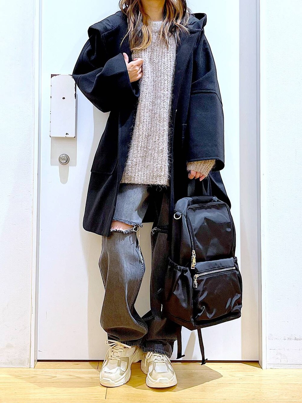 ブラック系のバックパック/リュック、ブラック系のその他アウター、ベージュ系のスニーカーを着用したレディースの冬コーディネートの6枚目の写真