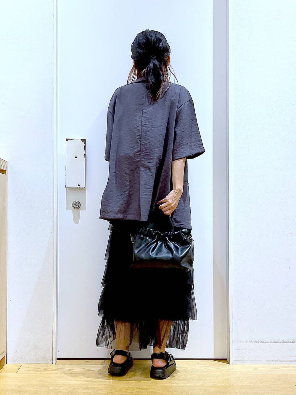 ブラック系のサンダル、ブラック系のショルダーバッグ、ブラック系のスカートを着用したレディースの夏コーディネートの5枚目の写真