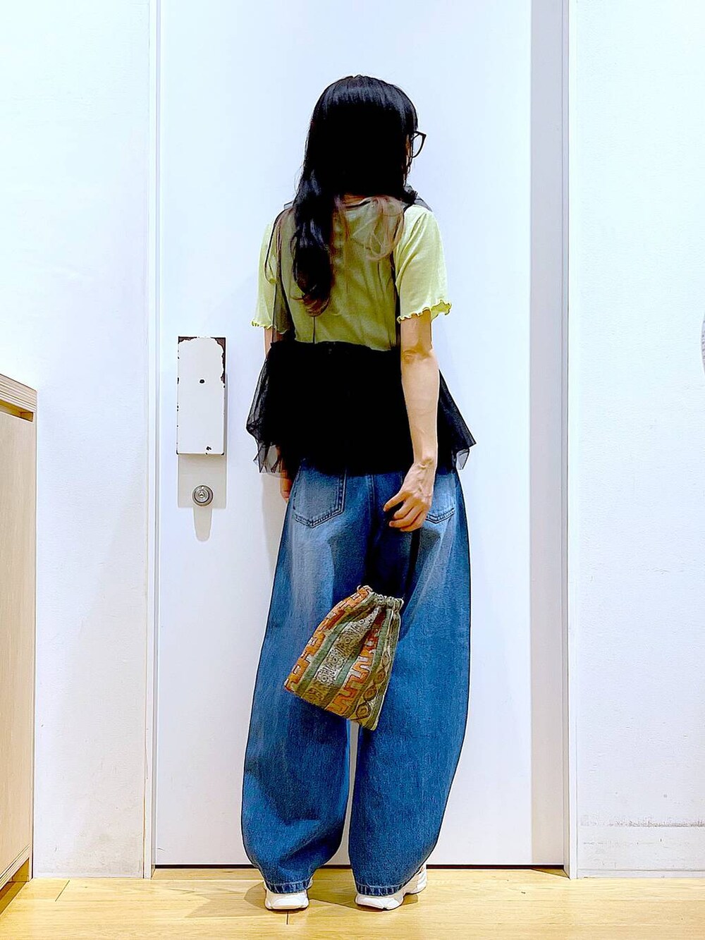 ブラウン系のショルダーバッグ、ホワイト系のサンダル、ブルー系のデニムパンツを着用したレディースの夏コーディネートの6枚目の写真