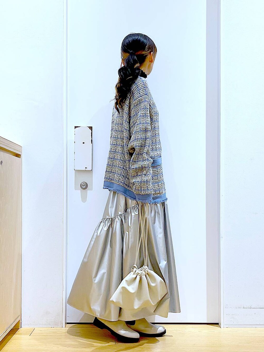 ブラック系のTシャツ/カットソー、シルバー系のスカート、ブルー系のカーディガン/ボレロを着用したレディースの冬コーディネートの4枚目の写真