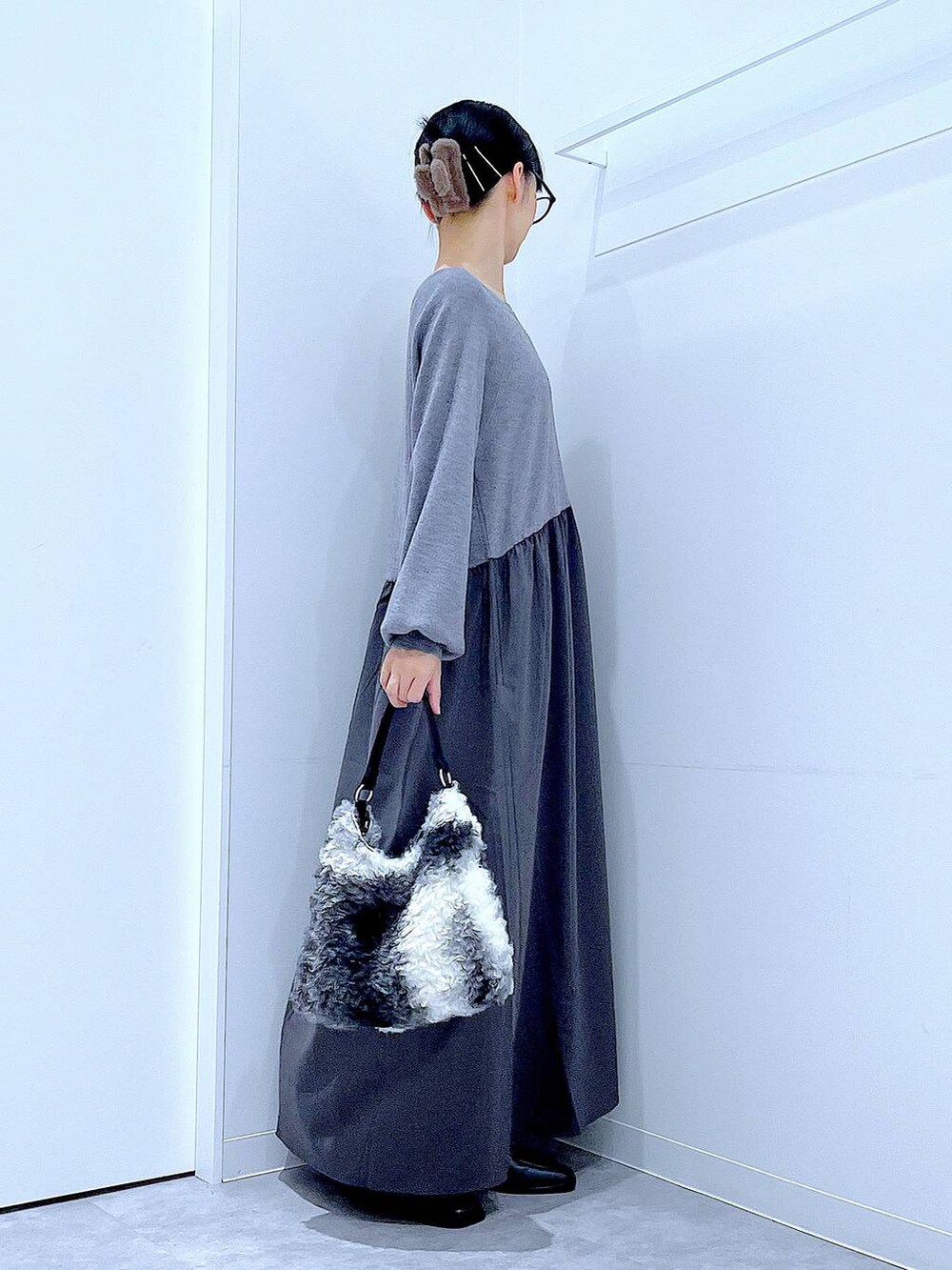 ブラック系のブーツ、ブラック系のショルダーバッグ、グレー系のワンピースを着用したレディースの秋コーディネートの4枚目の写真