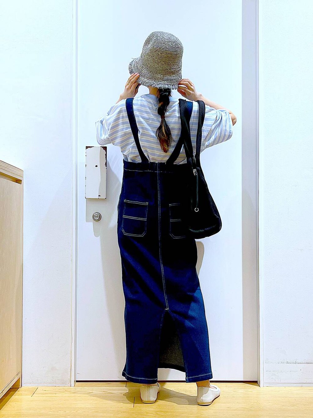 ホワイト系のパンプス、ブルー系のジャンパースカート、ブラック系のショルダーバッグを着用したレディースの夏コーディネートの5枚目の写真