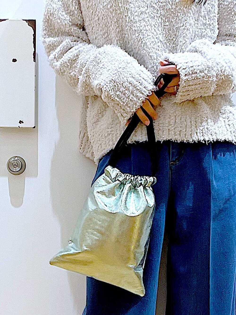 グレー系のニット/セーター、ブルー系のデニムパンツ、ベージュ系のブーツを着用したレディースの冬コーディネートの9枚目の写真