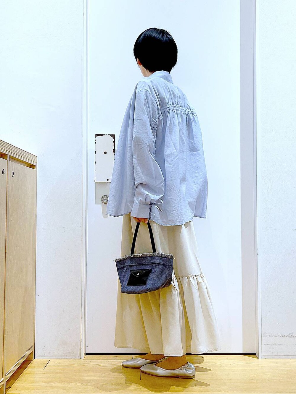 シルバー系のパンプス、ブルー系のショルダーバッグ、ブルー系のシャツ/ブラウスを着用したレディースの春コーディネートの3枚目の写真