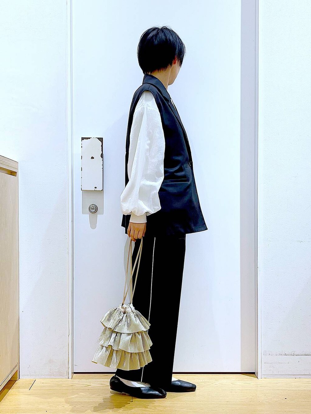 ブラック系のスラックス、ブラック系のパンプス、ホワイト系のスウェットを着用したレディースの春コーディネートの4枚目の写真