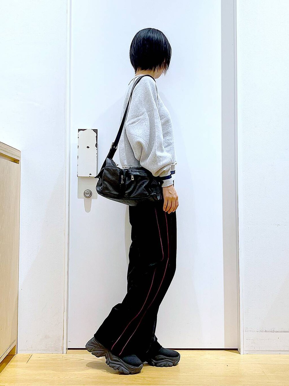 ブラック系のブーツ、ブラック系のその他パンツ、ブラック系のショルダーバッグを着用したレディースの冬コーディネートの4枚目の写真