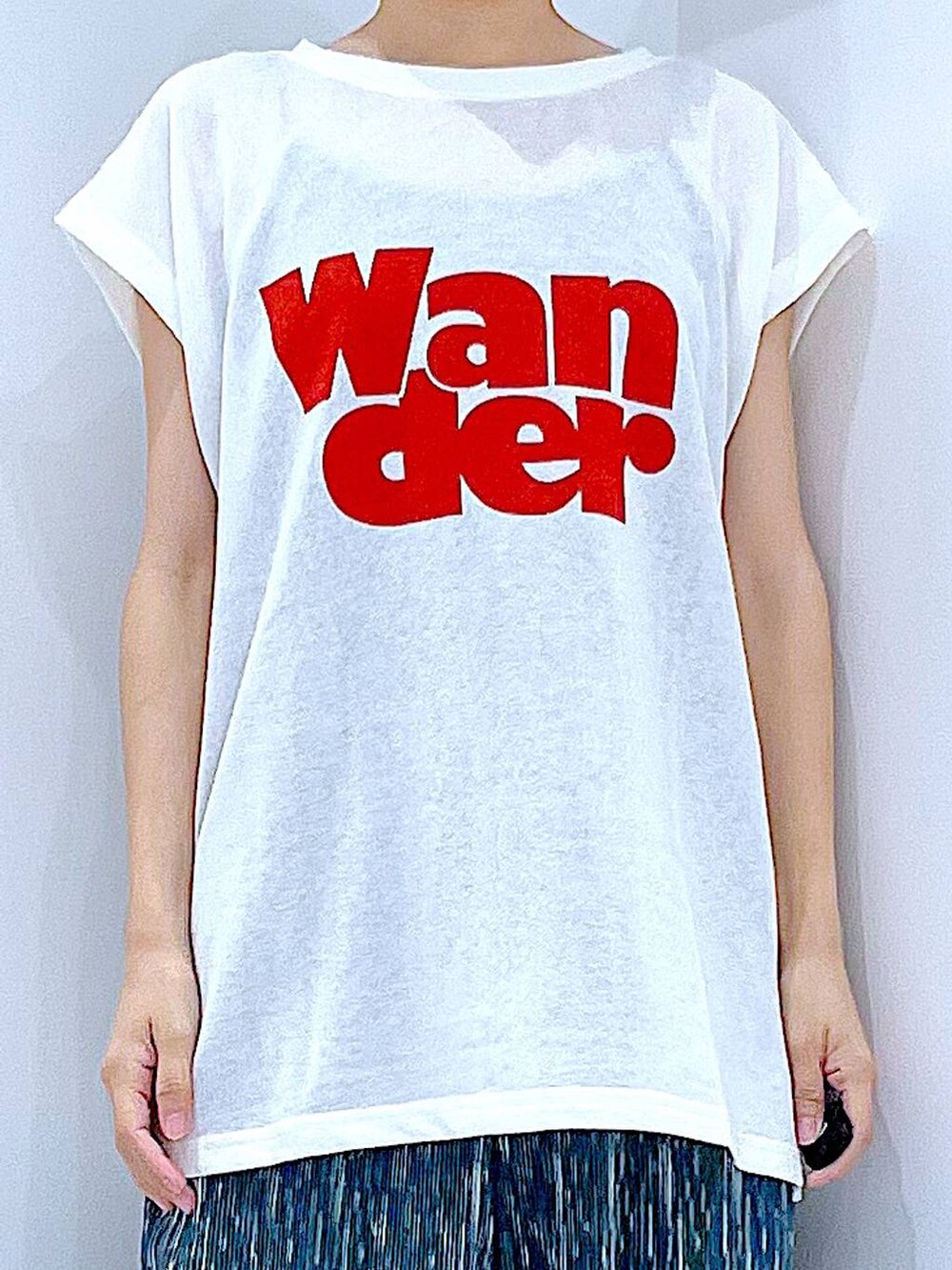 ブラック系のスニーカー、ホワイト系のTシャツ/カットソー、ホワイト系のトートバッグを着用したレディースの夏コーディネートの7枚目の写真