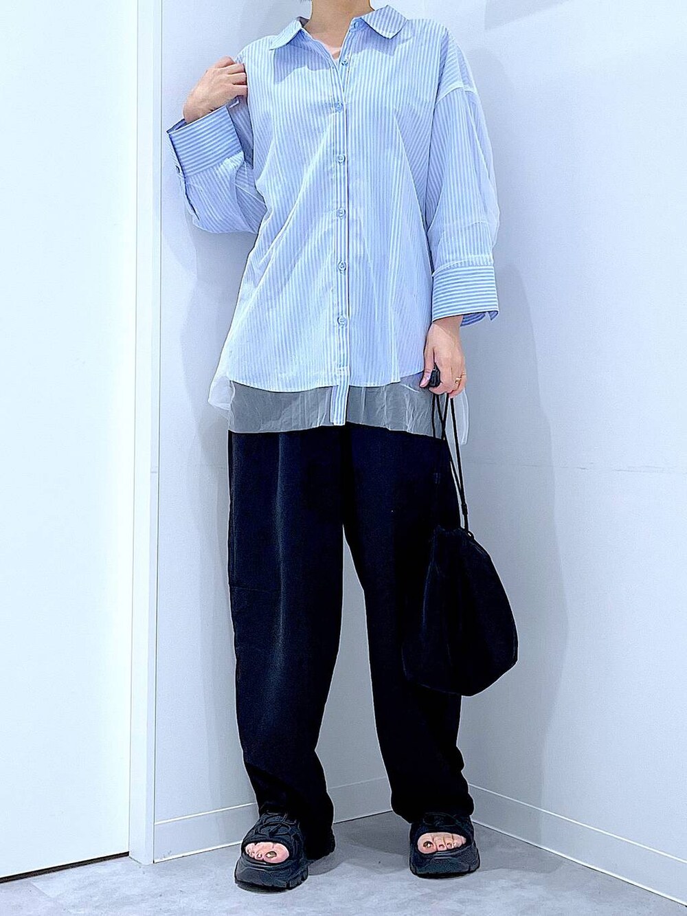 ブラック系のショルダーバッグ、ブラック系のその他パンツ、ブルー系のシャツ/ブラウスを着用したレディースの秋コーディネートの6枚目の写真