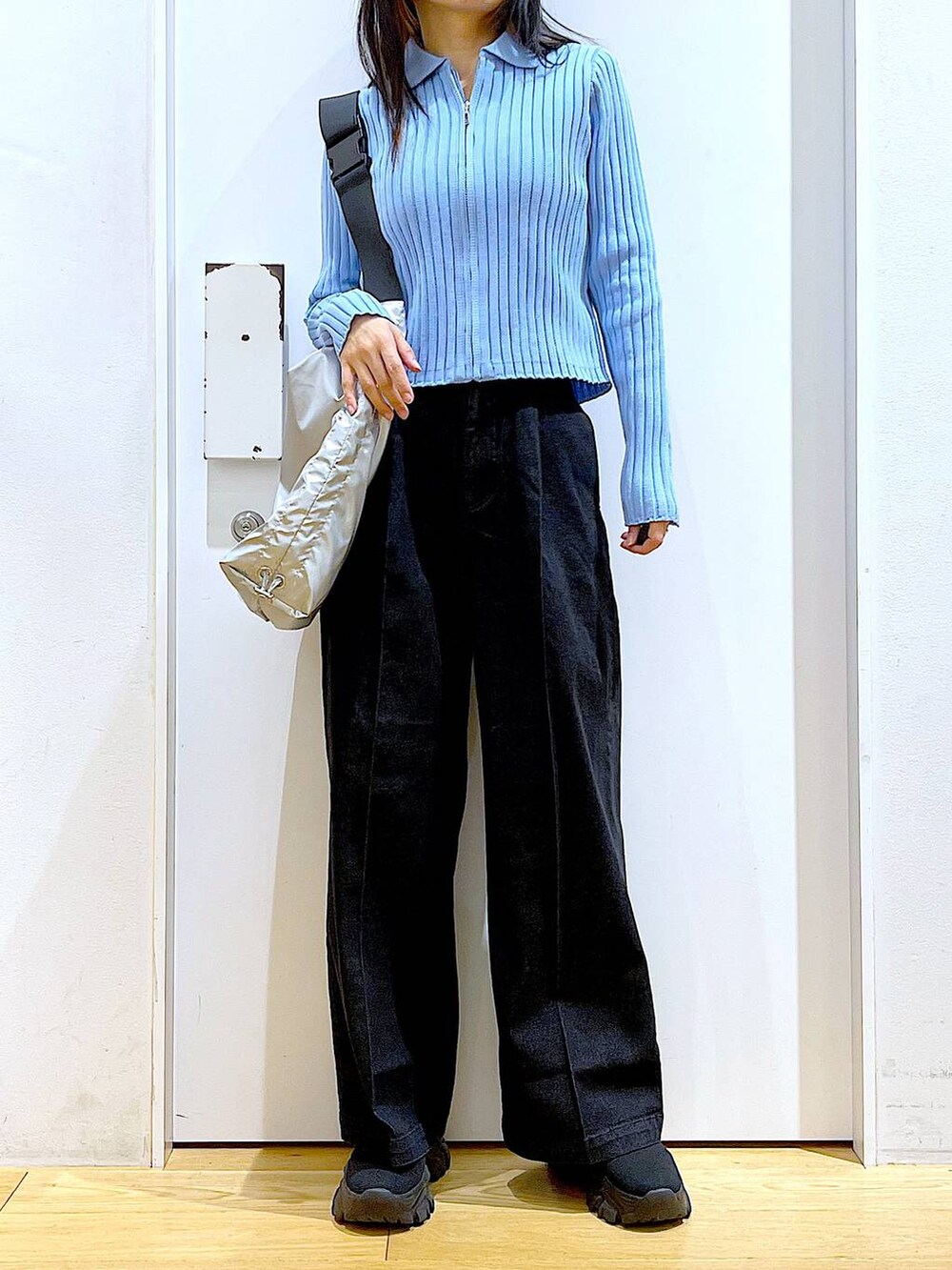 グレー系のデニムパンツ、ブルー系のカーディガン/ボレロ、ブラック系のブーツを着用したレディースの冬コーディネートの6枚目の写真