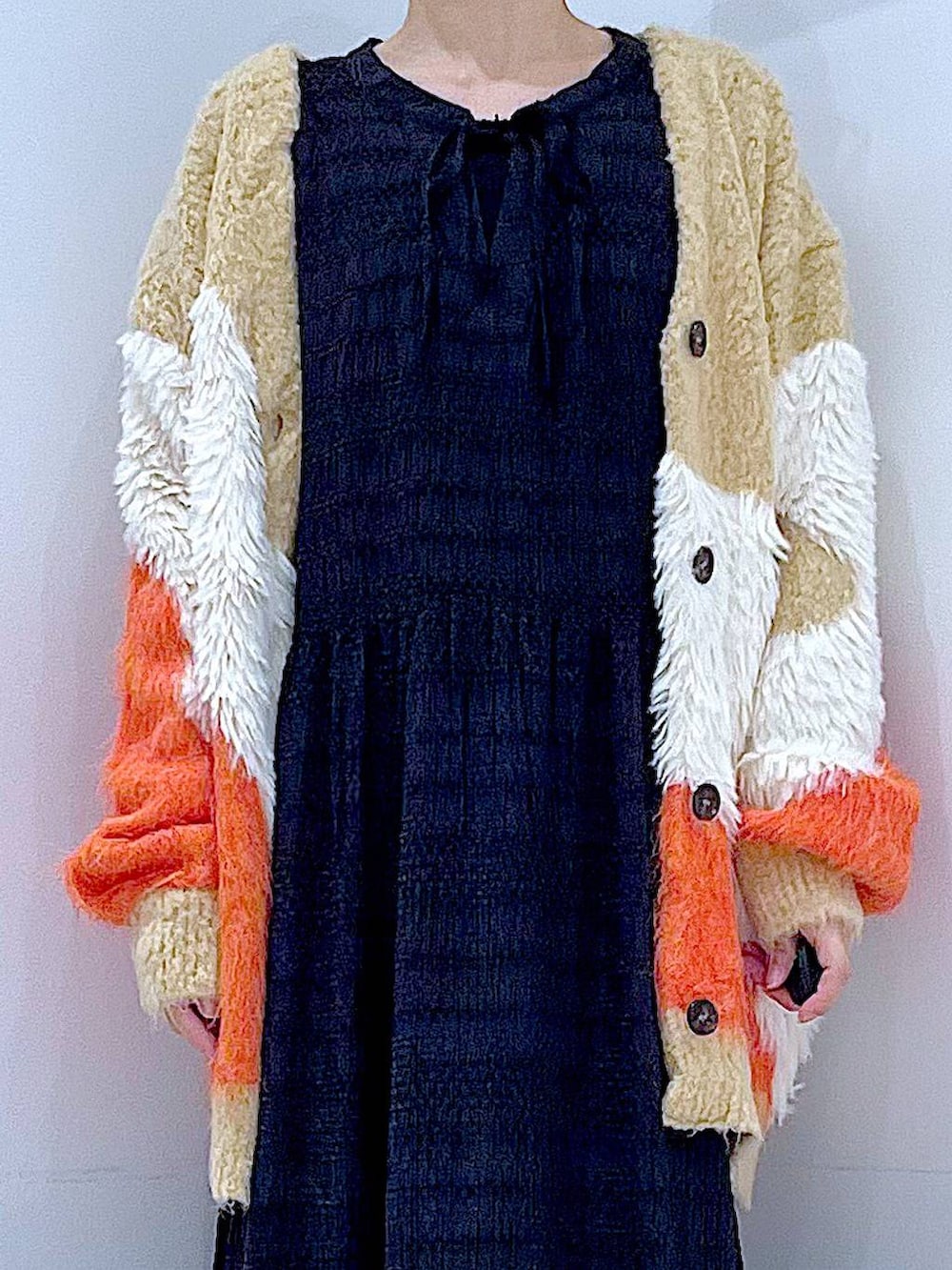 ブラック系のショルダーバッグ、ブラック系のローファー、オレンジ系のカーディガン/ボレロを着用したレディースの秋コーディネートの7枚目の写真