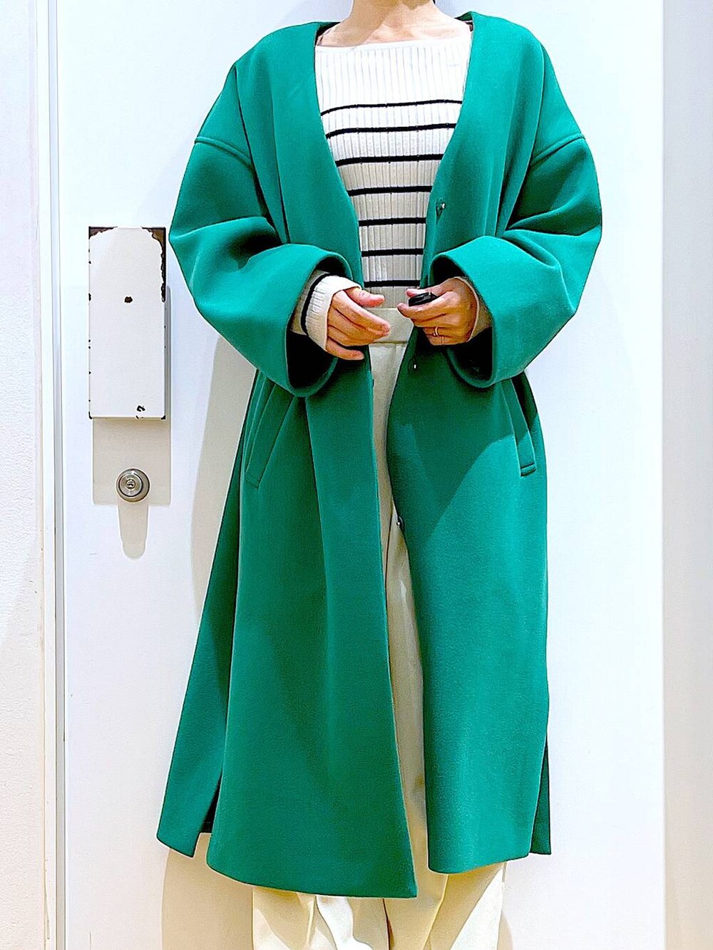 グレー系のショルダーバッグ、ホワイト系のニット/セーター、ベージュ系のブーツを着用したレディースの冬コーディネートの7枚目の写真