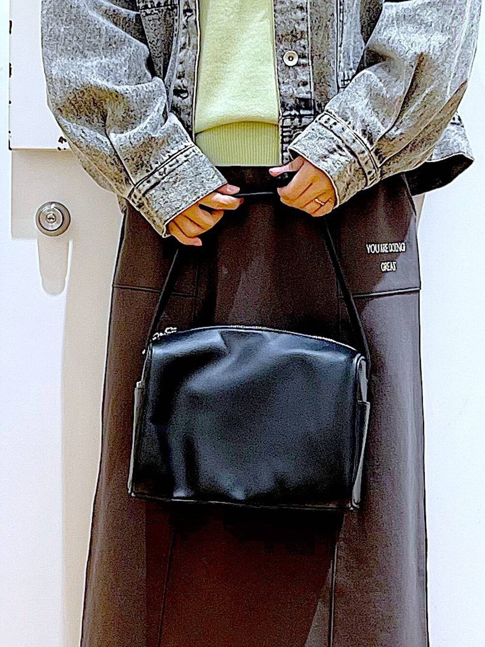 ブラック系のショルダーバッグ、シルバー系のローファー、ブラック系のデニムジャケットを着用したレディースの春コーディネートの9枚目の写真