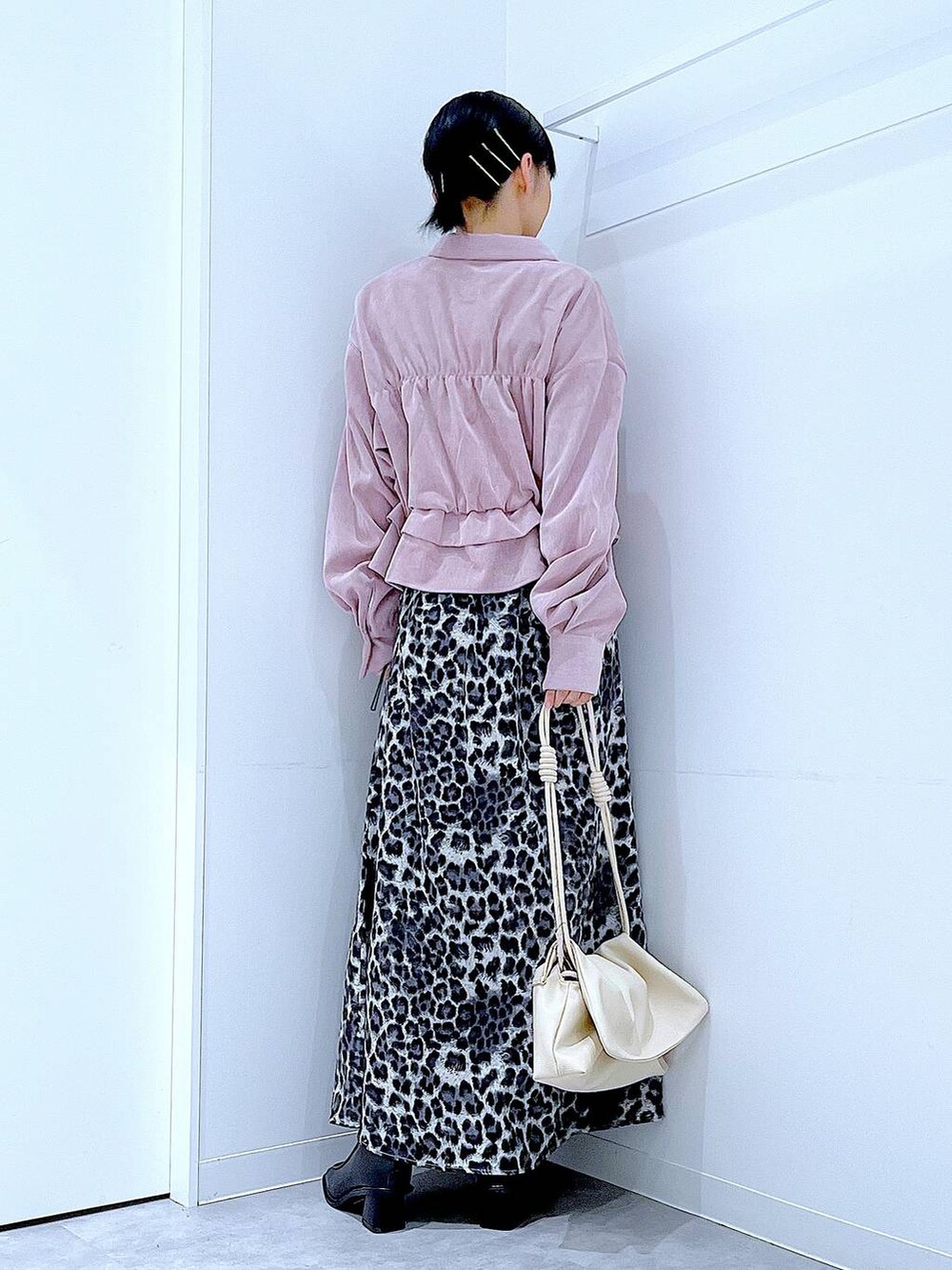 ホワイト系のショルダーバッグ、ブラック系のブーツ、グレー系のスカートを着用したレディースの秋コーディネートの5枚目の写真