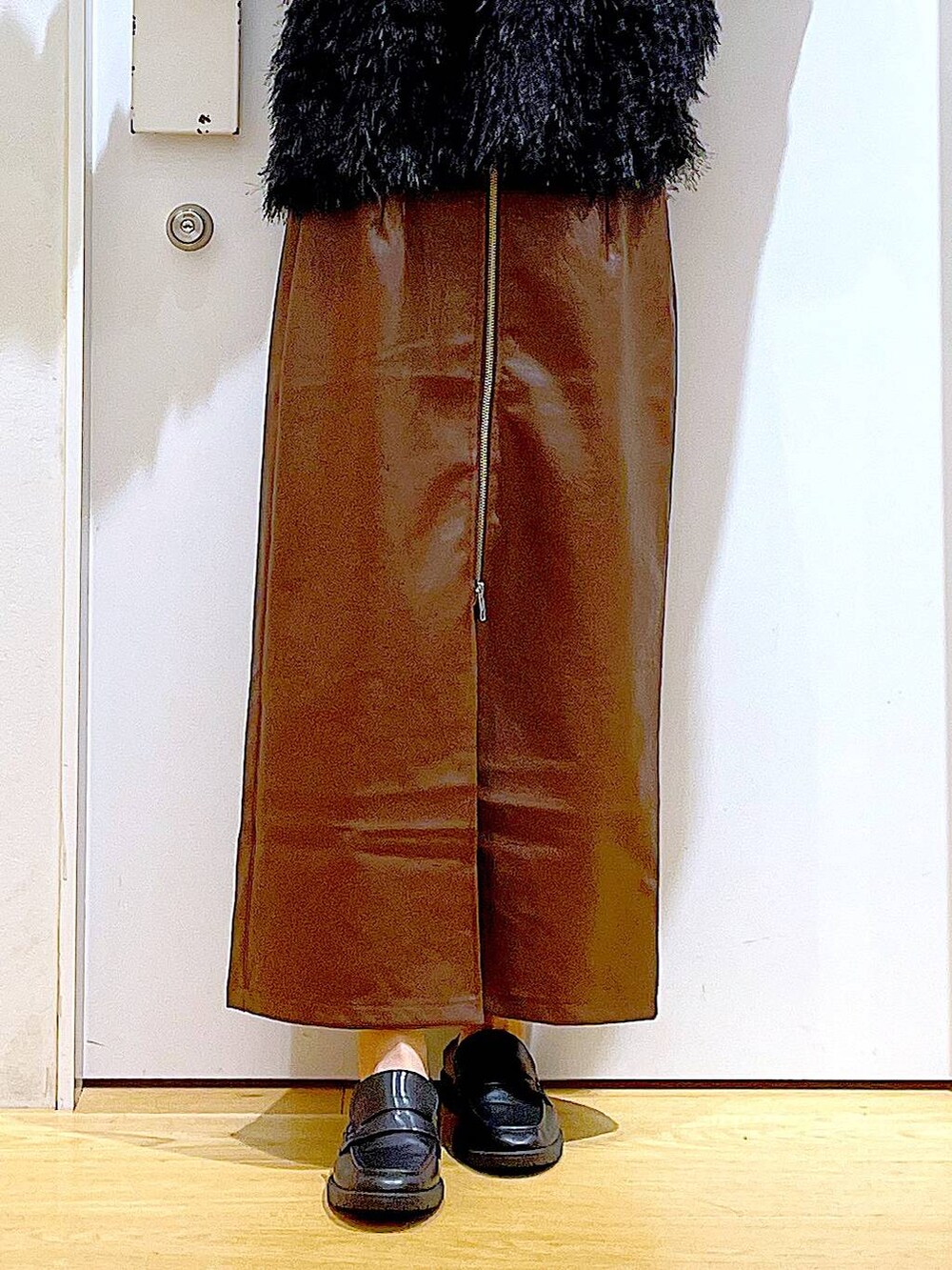 ブラウン系のスカート、ブラック系のショルダーバッグ、ホワイト系のTシャツ/カットソーを着用したレディースの秋コーディネートの8枚目の写真