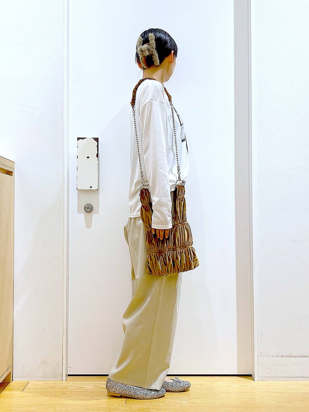 シルバー系のパンプス、イエロー系のショルダーバッグ、ベージュ系のその他パンツを着用したレディースの秋コーディネートの4枚目の写真