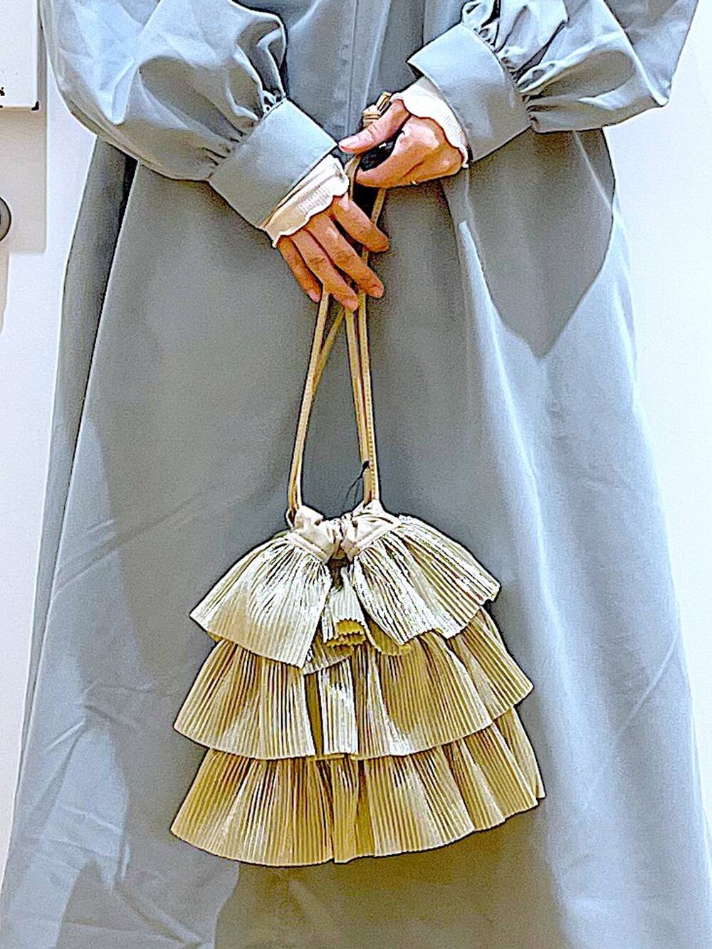 ベージュ系のTシャツ/カットソー、ホワイト系のパンプス、ベージュ系のショルダーバッグを着用したレディースの春コーディネートの9枚目の写真