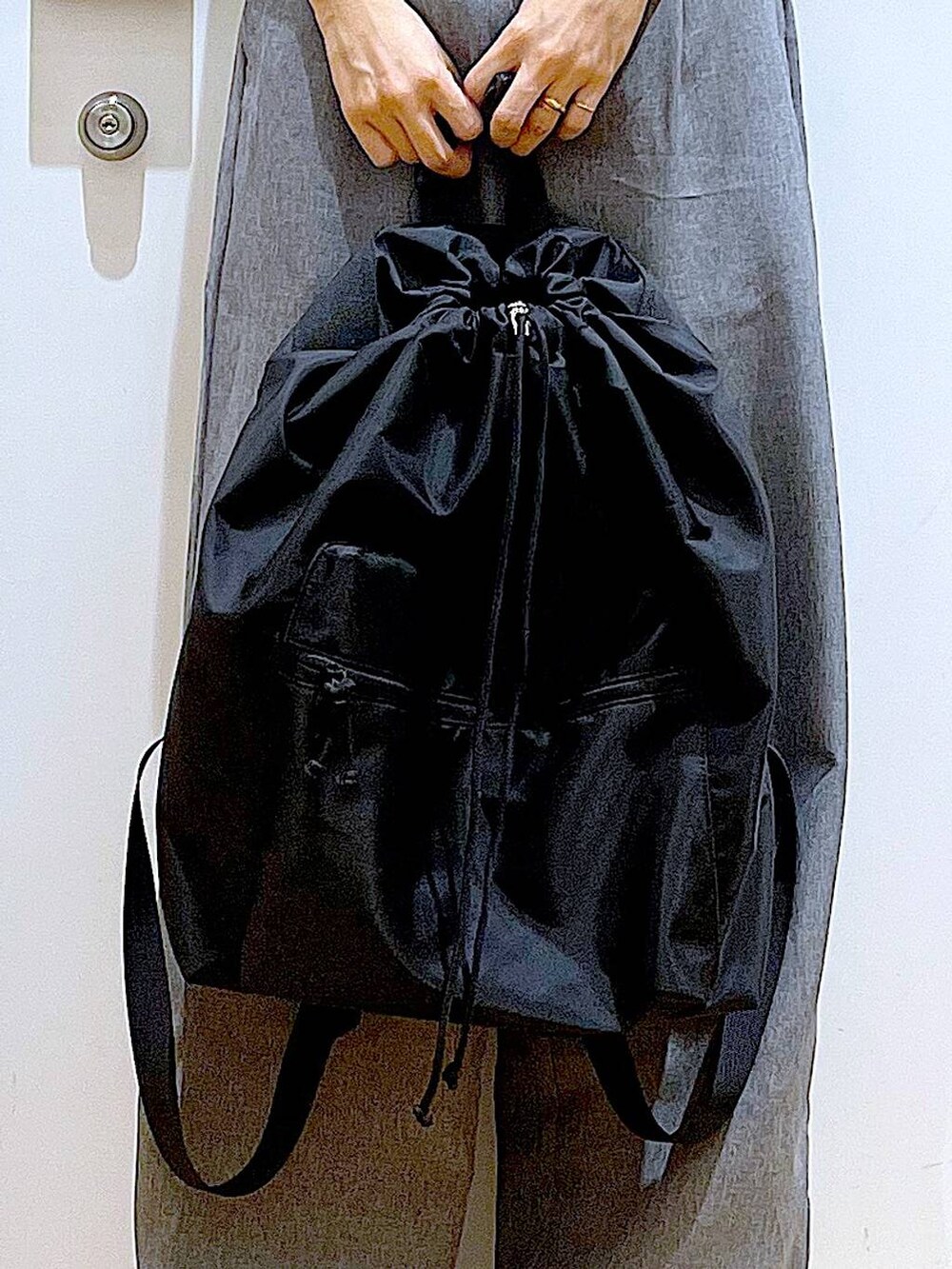 ブラック系のスニーカー、ブラック系のバックパック/リュック、グレー系のその他パンツを着用したレディースの春コーディネートの9枚目の写真