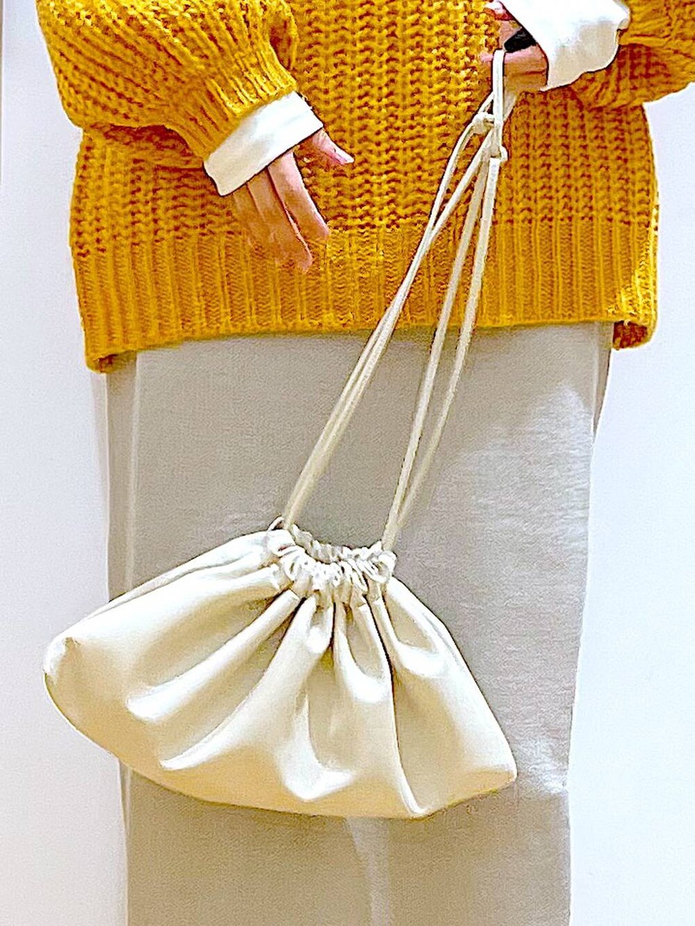 グレー系のスカート、ベージュ系のブーツ、ベージュ系のショルダーバッグを着用したレディースの冬コーディネートの9枚目の写真