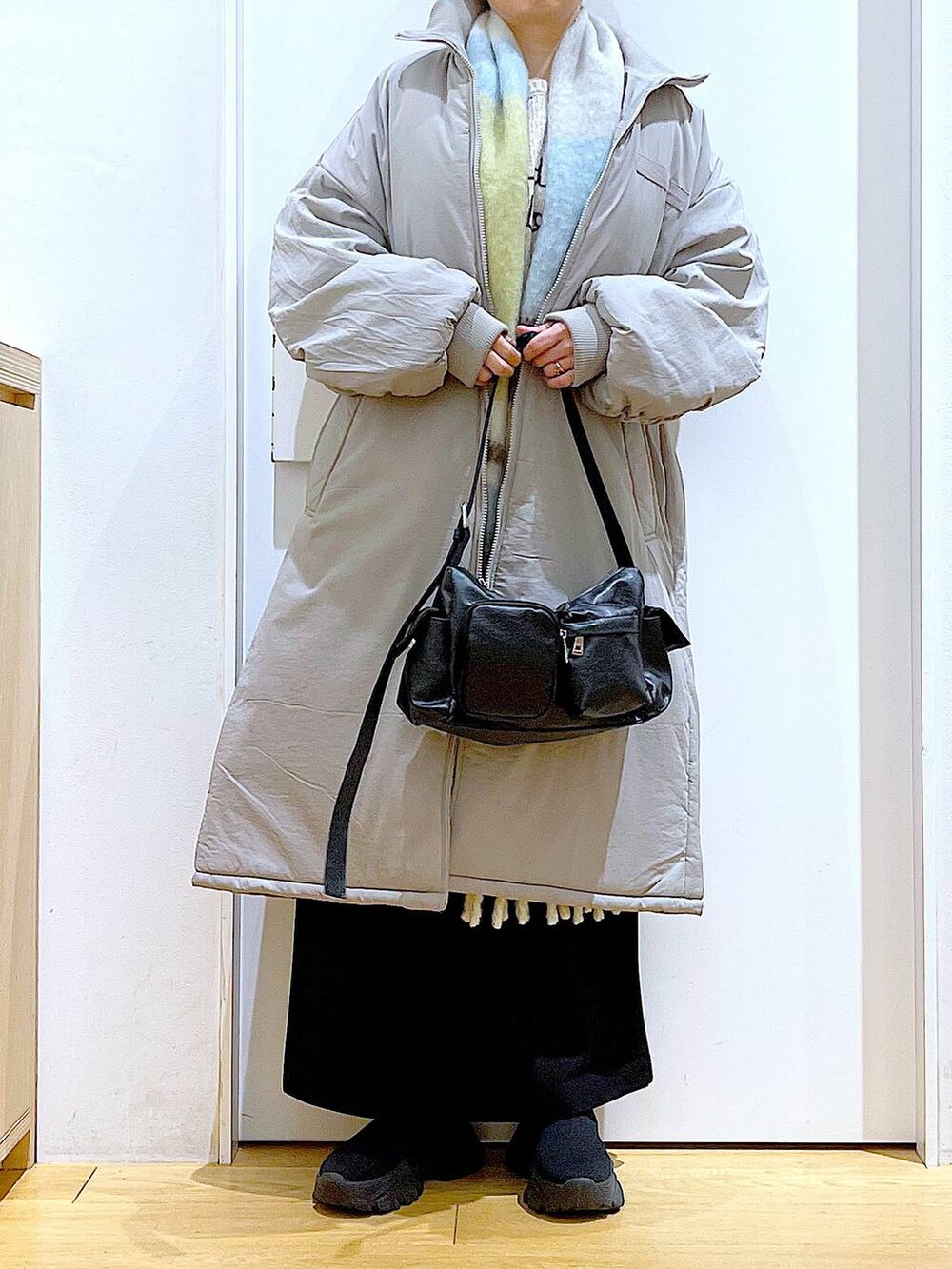 グレー系のミリタリージャケット、ブラック系のブーツ、ブラック系のショルダーバッグを着用したレディースの冬コーディネートの6枚目の写真